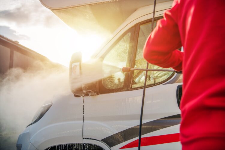 man cleaning a motorhome with a pressure washer